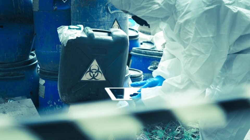 Man in HAZMAT suit inspecting dangerous goods
