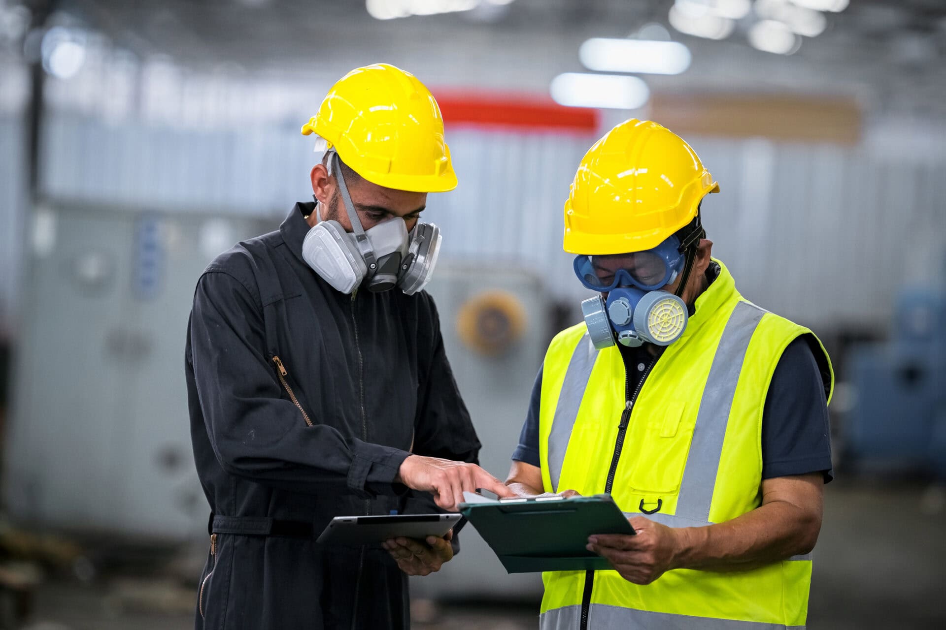 Two Officers Wearing Gas Masks, Holding Tablet And Book, Inspect The Chemical Spill Site In An Industrial Warehouse To Assess The Damage, Wearing Gas Masks, Inspecting And Evaluating Toxicity Of Leak.